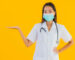 Portrait beautiful young asian doctor woman with mask for protect covid19 or coronavirus on yellow isolated background